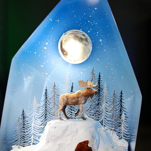 Reindeer in a winter forest lamp